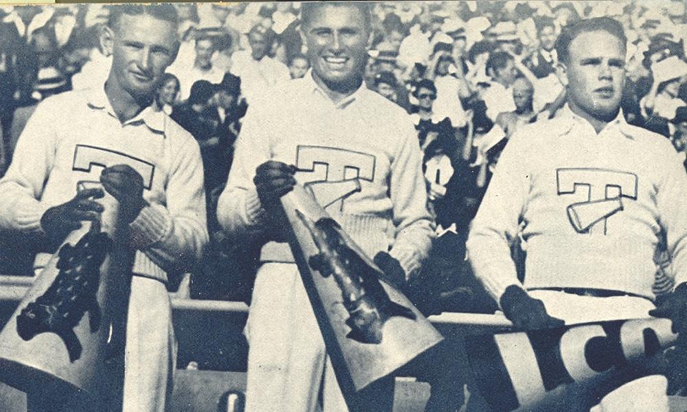 三名1934年TCU的男性大喊领袖拿着扩音器微笑