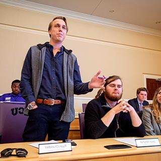 在学生会会议室举行的TCU学生会会议上，一名男学生站着发言.